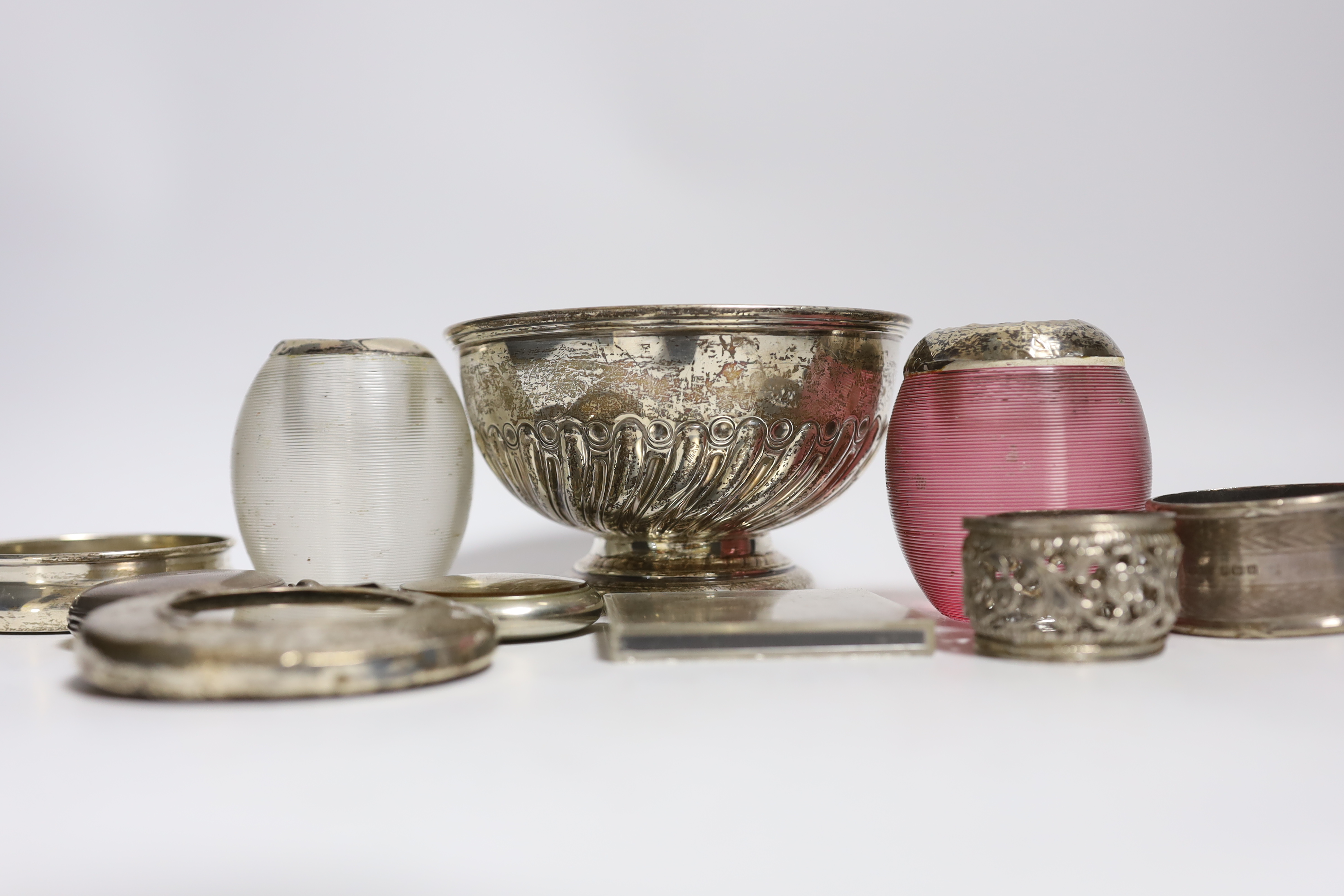 A collection of small silver, to include two mounted glass match strikes, one with cranberry glass, 71mm, a demi fluted bowl, photograph frame, napkin ring, lid and pocket watch, together with one other pocket watch, a c
